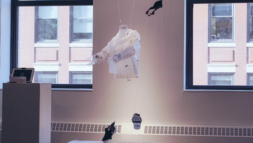 A white jacket, gloves and black shoes suspended in midair by transparent wires
