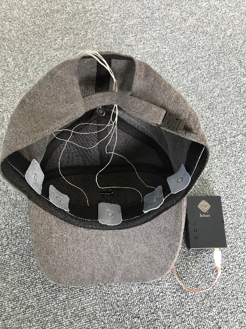 A picture of the inside of a baseball cap with wires connected to sensors along the forehead band