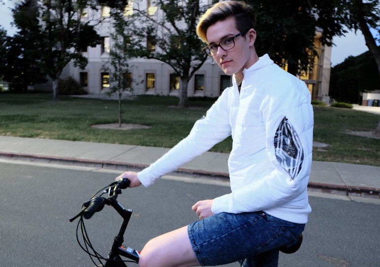 A man sitting on a bicycle wearing a white jacket