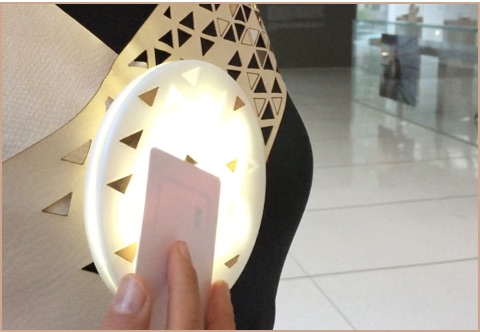 A circular illuminated object with a small card held in front of it